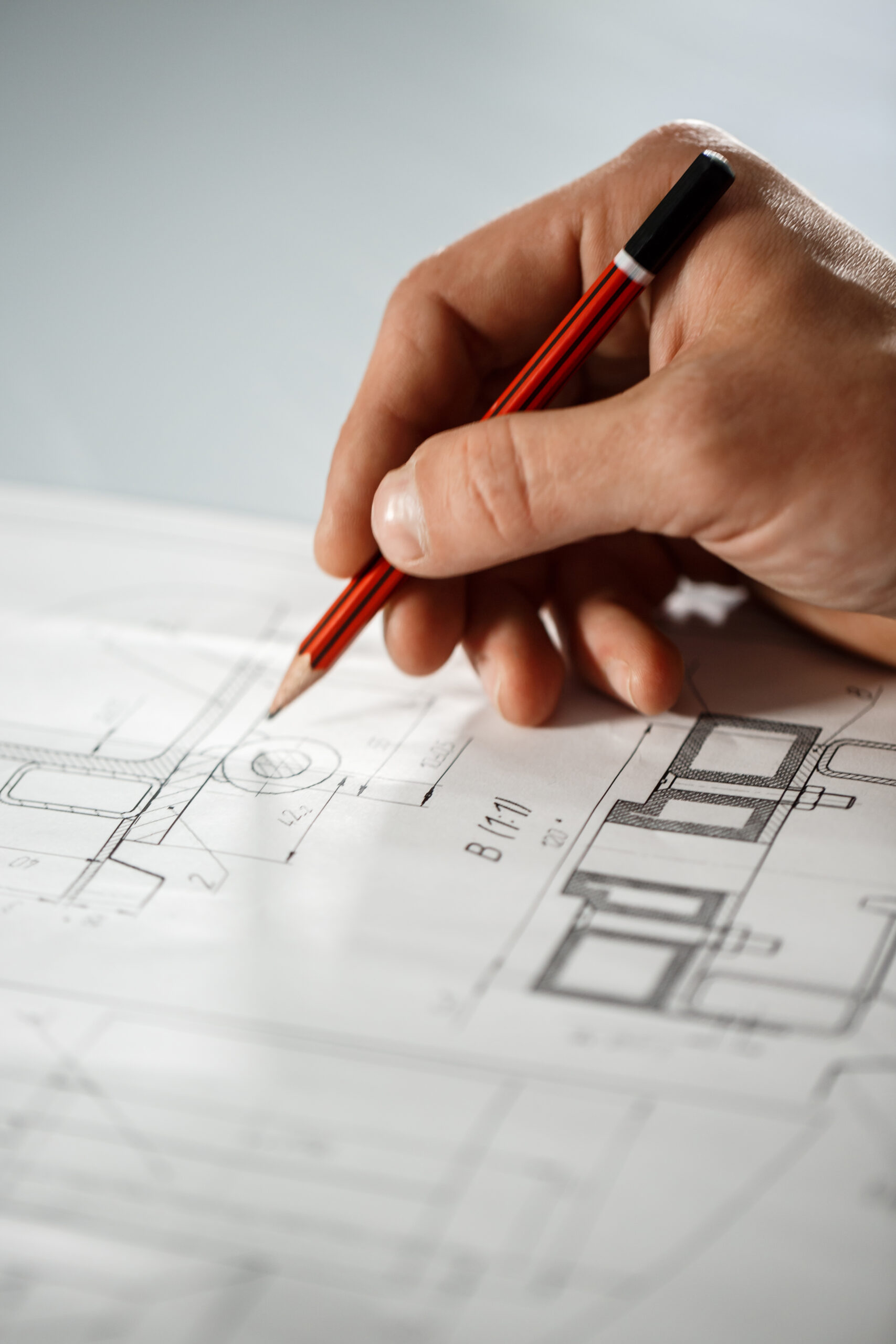 Close up photo of worker's hand on drawing.